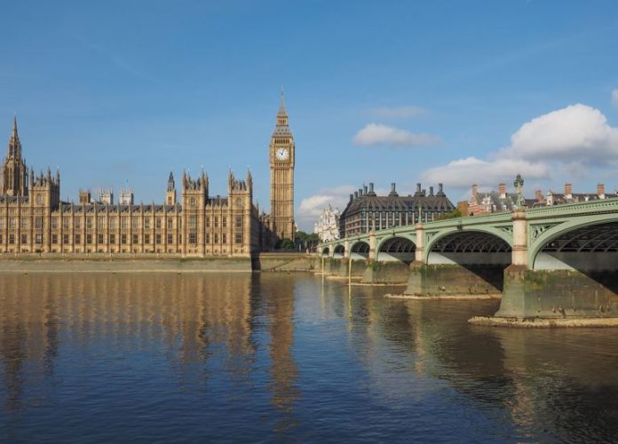 Houses of Parliament aka Westminster Palace and Westminster Bridge over River Thames in London, UK