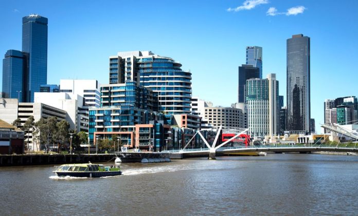 Touristic boat on Yarra river with downtown Melbourne in background in Australia